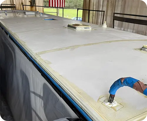 Roof coating in progress on a travel trailer